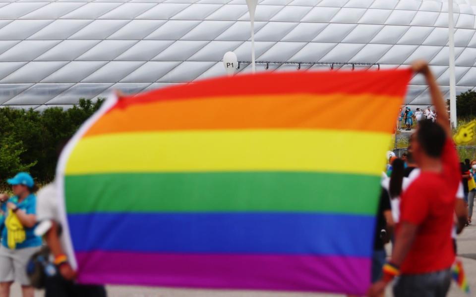  Fans hold rainbow flags outside the stadium before the matc - Reuters