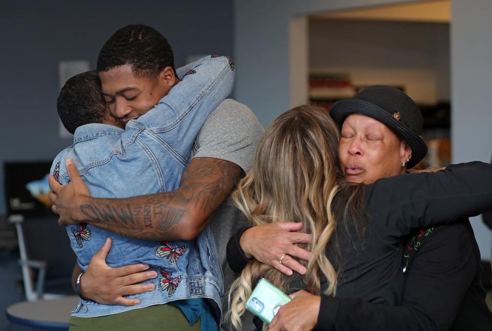 Akron Zips wide receiver Jalen Knight, left, hugs his mother Alrae Greene as his grandmother Cynthia Taylor, right, hugs Brittany Wrobleski, local organizer for Progressive's Keys to Progress program, after finding out Jalen was selected to win a brand new car on Tuesday.