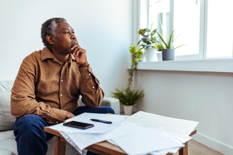 Person with a serious expression sitting in front of paperwork.