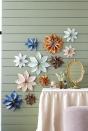 <p>Transform wallpaper remnants into floating flowers. Trace and cut out 8 to 12 (depending on sizes) petals on backs of wallpaper remnants. Pinch together one end of each petal, and secure with hot-glue. Once dry, glue petals together in a circle. Secure to wall with pushpins.</p><p><strong>Get the step-by-step how-to:</strong> <a href="https://www.countryliving.com/diy-crafts/a35281093/wallpaper-flowers/" rel="nofollow noopener" target="_blank" data-ylk="slk:How to Make Wallpaper Flowers;elm:context_link;itc:0;sec:content-canvas" class="link ">How to Make Wallpaper Flowers</a></p>