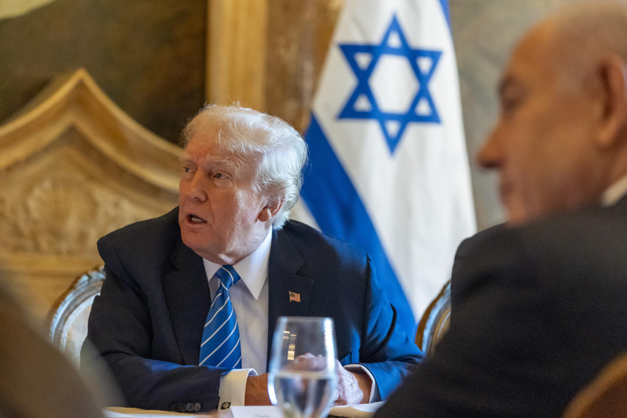 Former President Donald Trump, left, meets with Israeli Prime Minister Benjamin Netanyahu, at Mar-a-Lago. An Israeli flag stands behind Trump.