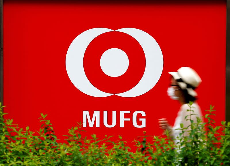 FILE PHOTO: A woman walks past a branch of Mitsubishi UFJ Financial Group's bank of Tokyo-Mitsubishi UFJ (MUFG) in Tokyo