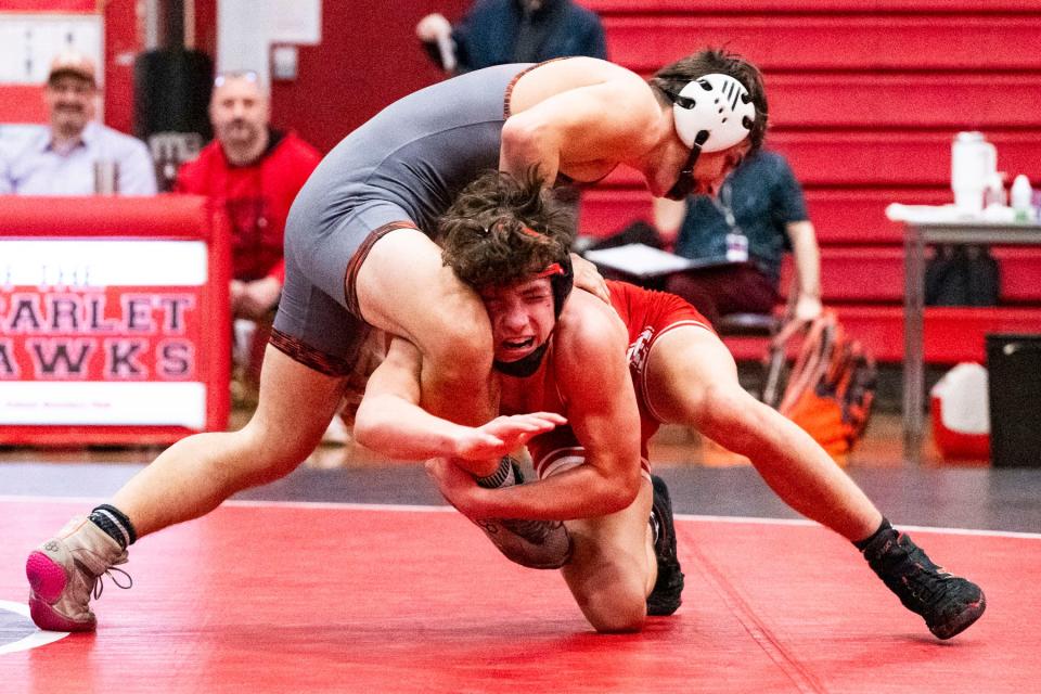 Milford wrestler Mikey Boulanger attempts to take down Taunton’s John Mandeville In their 144 lb. match at Milford High, Jan. 10, 2024. Boulanger notched his 100th varsity win with the victory.