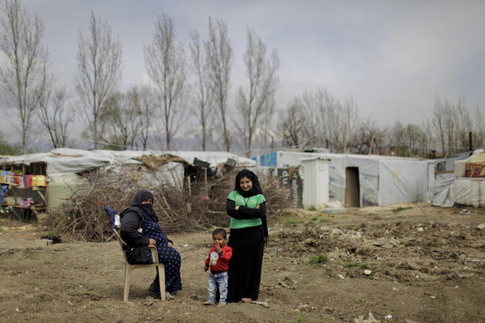 A Syrian refugee woman poses for a picture with her daughter a her son at an informal refugee camp, at Al-Marj town in Bekaa valley, east Lebanon Lebanon, Saturday, April 8, 2017. For the millions of Syrian refugees scattered across camps and illegal settlements across the region, the chemical attack on a town in northern Syria and subsequent U.S. strike was a rare moment when the world briefly turned its attention to Syria, before turning away again. (AP Photo/Hassan Ammar)