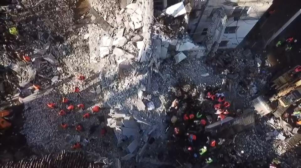 In this aerial view taken from a video by AFPTV, emergency workers clear debris at a damaged building in Thumane, 34 kilometres (about 20 miles) northwest of capital Tirana (ELIS KRUJA/AFP via Getty Images)