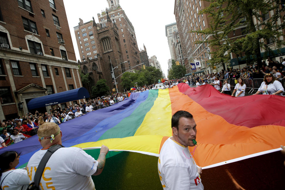 In this June 28, 2015 file photo, participants carry a rainbow-colored flag down Fifth Avenue in New York during the Heritage Pride March in New York. One of the biggest celebrations of LGBT pride in New York City history will culminate Sunday, June 30, 2019, with not one, but two processions through the streets of Manhattan, after dissidents who believe the annual parade has become too commercialized decided to split off with their own march. (AP Photo/Kathy Willens, File)