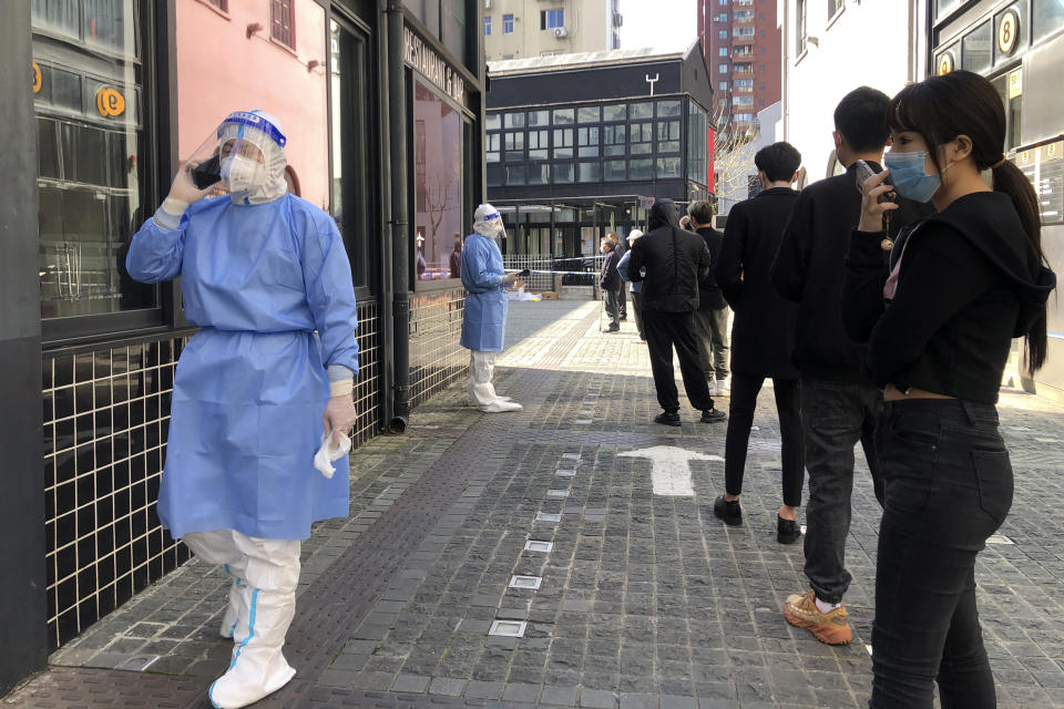 Residents line up for mass testing in a lockdown area in the Jingan district of western Shanghai, Monday, April 4, 2022. China has sent more than 10,000 health workers from across the country to Shanghai, including 2,000 military medical staff, as it struggles to stamp out a rapidly spreading COVID-19 outbreak in China's largest city. (AP Photo/Chen Si)