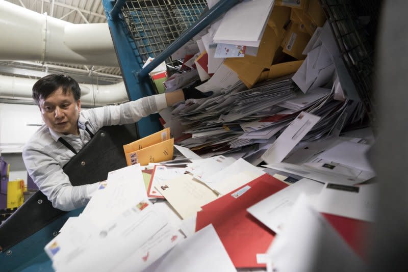 A postal employee sorts incoming mail at the U.S. Postal Service Suburban Processing and Distribution Center in Gaithersburg, Md., on December 19. On May 15, 1918, the first regular U.S. airmail service was established between Washington and New York City. File Photo by Kevin Dietsch/UPI