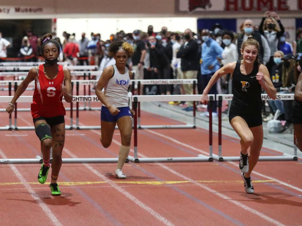 Padua's Sophia Curtis (right), shown here heading for the finish line at the DIAA Indoor meet, won four events Saturday to help the Pandas earn their 10th consecutive team title at the New Castle County Track and Field Championships at Abessinio Stadium.