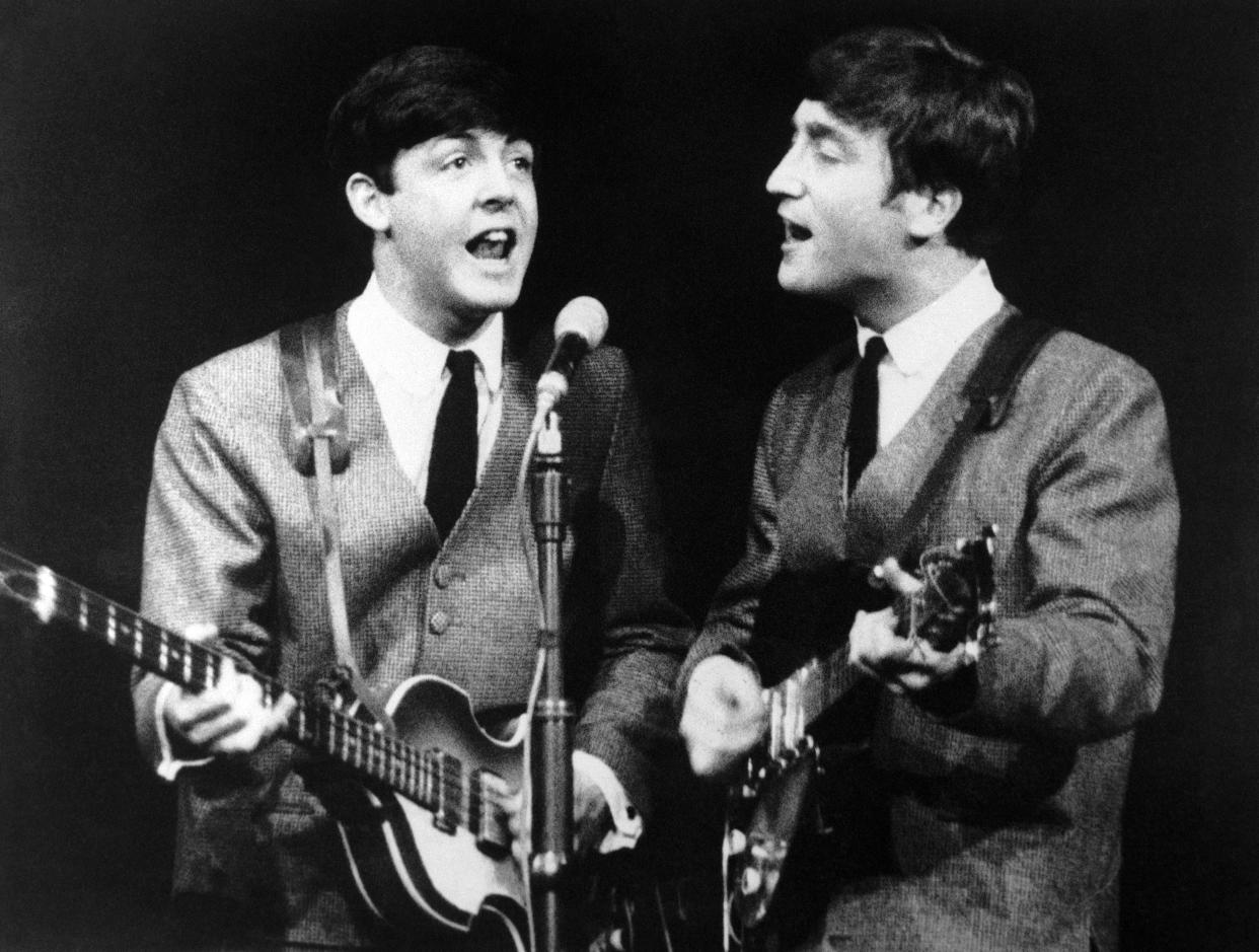 Paul McCartney, left, and John Lennon, two members of the Beatles pop group during a concert in London, on Nov. 11, 1963. (AP Photo/N)