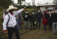 Free Peru party presidential candidate Pedro Castillo says goodbye to his neighbors as he leaves his home to prepare for his electoral campaign, in Chugur, Peru, Friday, April 16, 2021. Castillo, a rural teacher, who has proposed rewriting Peru's constitution and deporting all immigrants living in the country illegally who commit crimes, will face rival candidate Keiko Fujimori in the June 6 presidential run-off election. (AP Photo/Martin Mejia)