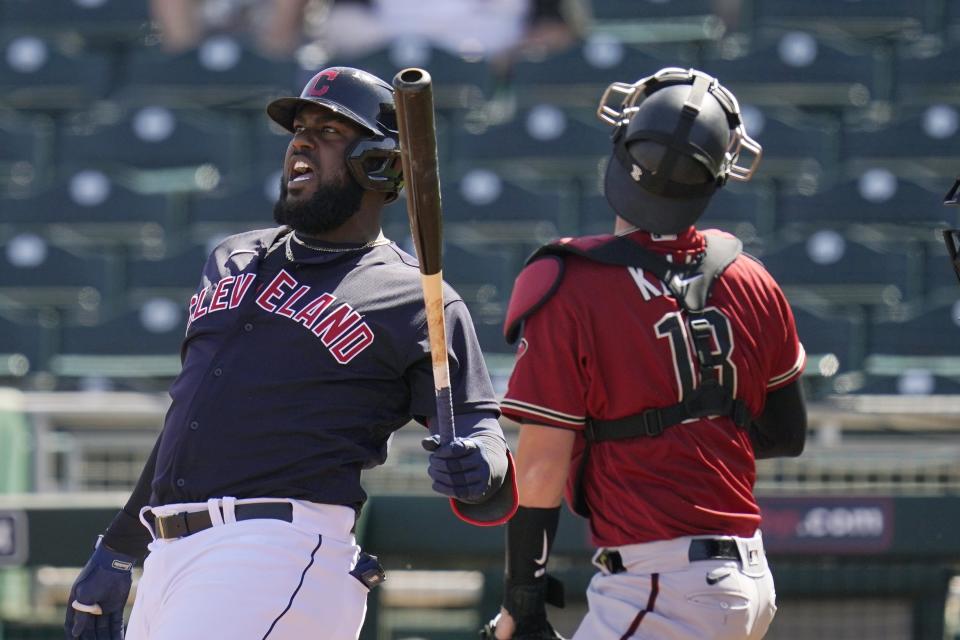 Cleveland Indians designated hitter Franmil Reyes, left, shouts after fouling off a pitch as Arizona Diamondbacks catcher Carson Kelly, right, looks for the ball during the second inning of a spring training baseball game Wednesday, March 3, 2021, in Goodyear, Ariz. (AP Photo/Ross D. Franklin)