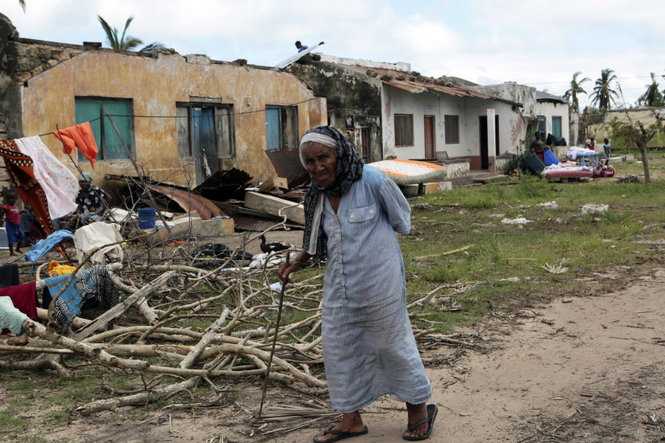 An elderly women walks past a house damaged by Cyclone Kenneth when it struck Ibo island north of Pemba city in Mozambique, Wednesday, May, 1, 2019. The government has said more than 40 people have died after the cyclone made landfall on Thursday, and the humanitarian situation in Pemba and other areas is dire. More than 22 inches (55 centimeters) of rain have fallen in Pemba since Kenneth arrived just six weeks after Cyclone Idai tore into central Mozambique. (AP Photo/Tsvangirayi Mukwazhi)