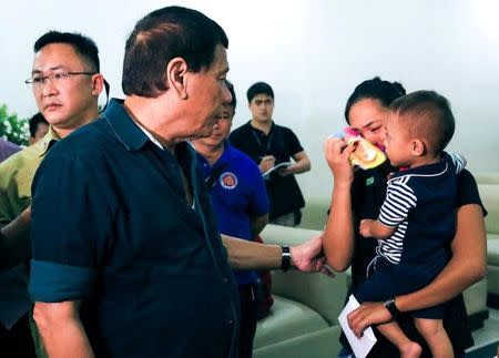 Philippine President Rodrigo Duterte comforts a woman as he visits the wake of soldiers killed in Marawi city during fighting with Muslims Maute group militants, in Iligan City, Philippines May 26, 2017. Malacanang Presidential Palace/Handout via Reuters