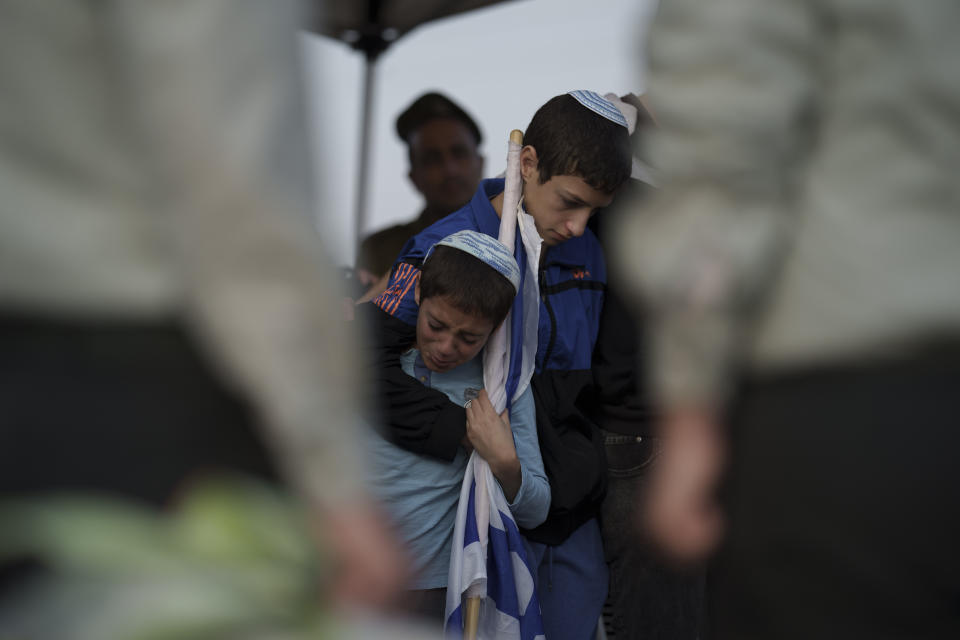 Relatives of the Israeli Captain Neriya Zisk mourn during his funeral at a cemetery in the village of Masu'ot Yitzhak, Israel, Thursday, Dec. 28, 2023. Zisk was killed in combat in the Gaza Strip. (AP Photo/Leo Correa)