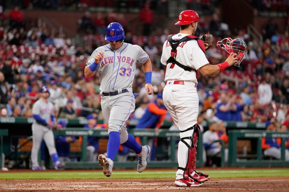 New York Mets' James McCann (33) scores past St. Louis Cardinals catcher Andrew Knizner during the third inning of a baseball game Tuesday, April 26, 2022, in St. Louis.