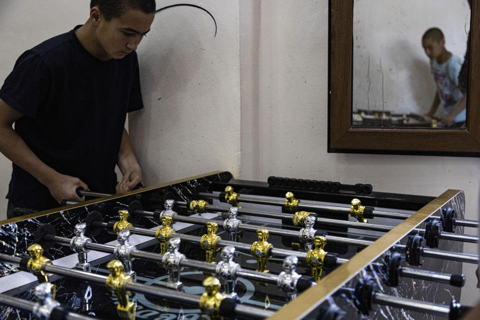 Children linked to the Islamic State group play foosball in a rehabilitation center outside Qamishli, Syria, Tuesday, May 11, 2023. The rehabilitation program attempts to teach teens to become more tolerant through drawing, music, sports, or vocational training. (AP Photo/Baderkhan Ahmad)