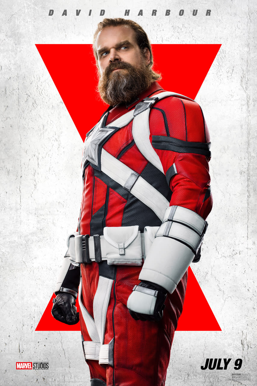 A bearded David Harbour as the Red Guardian, wearing a red suit with white accents and a white star on his chest.