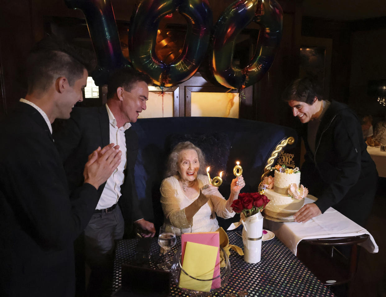 Magician Gloria Dea is honored by fellow magicians, from left, Lance Rich, David Sandy and David Copperfield during her 100th birthday celebration at the Westgate in Las Vegas on Thursday, Aug. 25, 2022. Dea, touted as the first magician to perform on what would become the Las Vegas Strip in the early 1940s, has died. One of Dea's caretakers said she died Saturday, March 18, 2023, at her Las Vegas residence. She was 100. (K.M. Cannon/Las Vegas Review-Journal via AP)