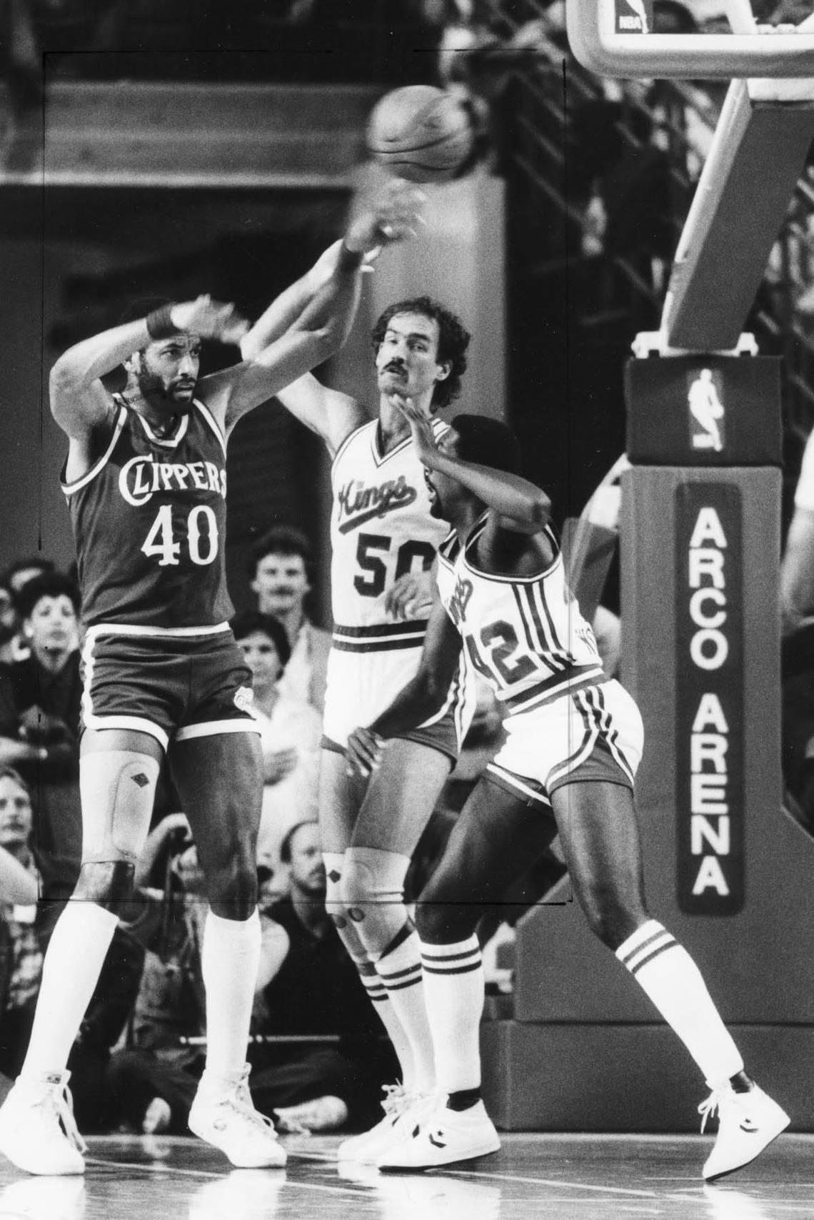 Los Angeles Clippers center James Donaldson (40), a Burbank High School graduate, passes as the Kings’ Rich Kelley (50) and Mike Woodson (42) defend at Arco Arena in November 1985.