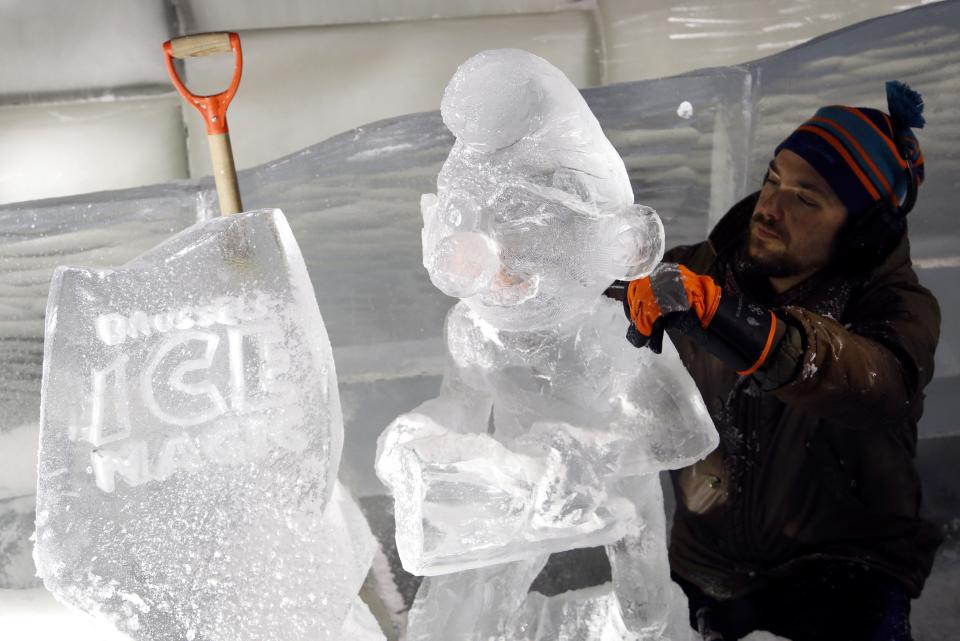 Sculptor Girard of Canada carves a sculpture based on characters from comic strips at the Brussels Ice Magic Festival