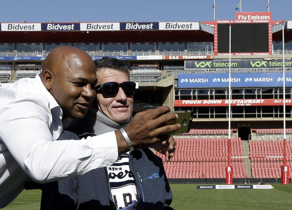 FILE - In this Wednesday, June 24, 2015 file photo, former rugby players Chester Williams, left, with teammate Joost van der Westhuizen, right, take a selfie during their 1995 Rugby World Cup-winning team reunion at Ellis Park stadium in Johannesburg, South Africa. Joost van der Westhuizen, who won the 1995 World Cup with South Africa as Nelson Mandela looked on, has died after a six-year-battle with motor neuron disease. He was 45. South Africa Rugby announced the death Monday, Feb. 6, 2017. (AP Photo/Themba Hadebe, file)