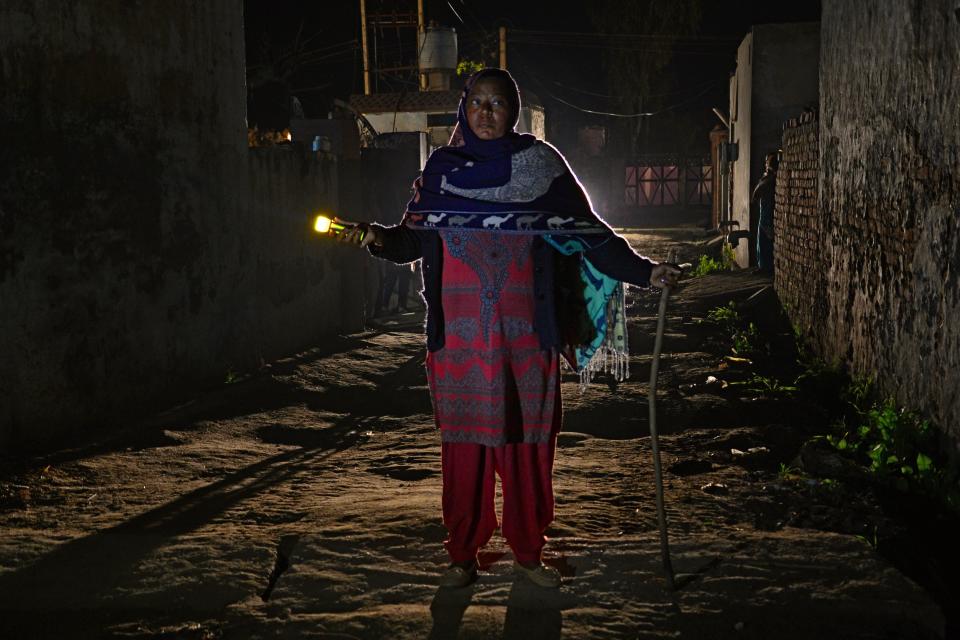 Kuldeep Kaur, 51, is an Indian watch woman for the Bhangiwal village near Mehatpur, India. Here she walks with a flashlight during her night round on&nbsp;Feb. 24, 2018.