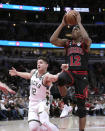 Chicago Bulls' Ayo Dosunmu shoots as Milwaukee Bucks' Grayson Allen defends during the first half of an NBA basketball game Thursday, Feb. 16, 2023, in Chicago. (AP Photo/Charles Rex Arbogast)