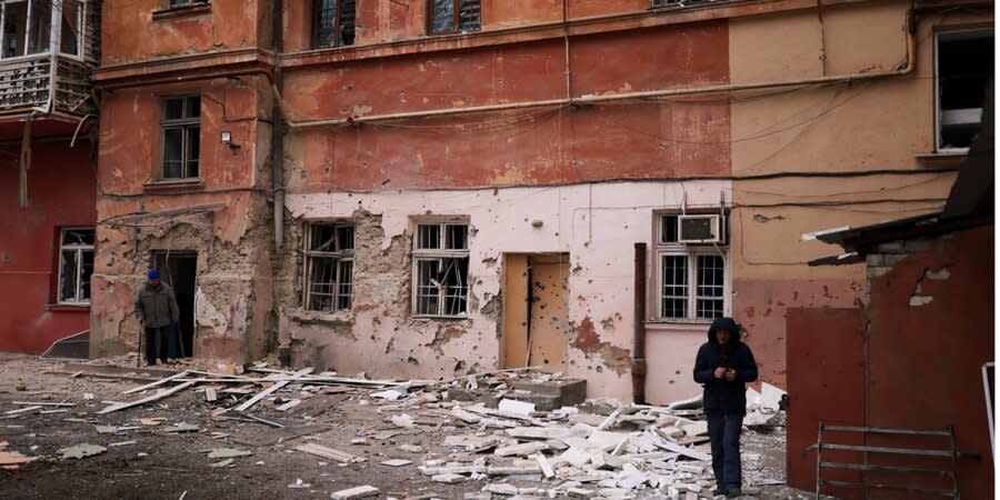 Local residents near houses damaged by Russian shelling in Kherson, January 25, 2023