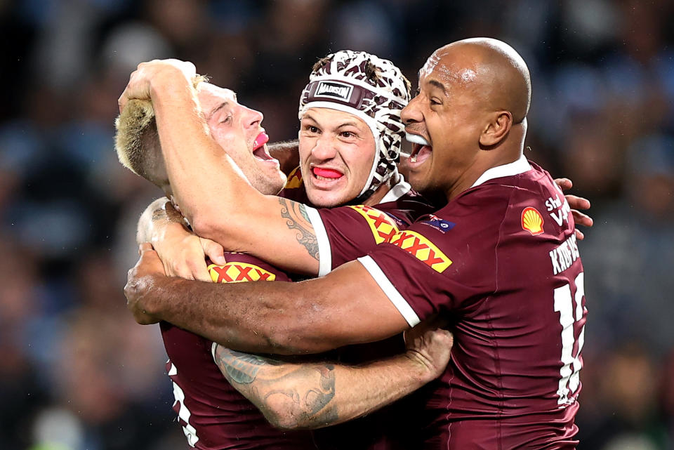 Cameron Munster, Kalyn Ponga and Felise Kaufusi embrace during State of Origin.