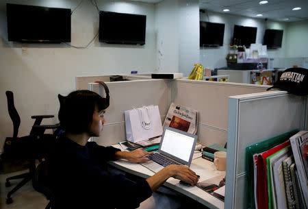 Oliver Emocling, 23, who works for a magazine, sits at his desk at a publishing company in Makati City, in Metro Manila, in Philippines, October 15, 2018. REUTERS/Eloisa Lopez