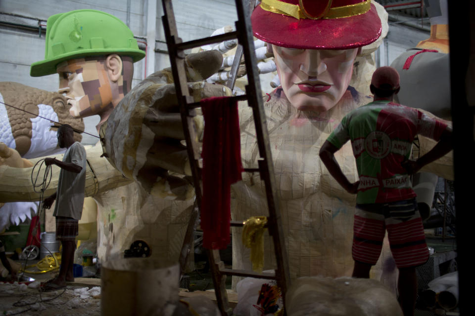 In this photo taken Tuesday, Jan. 22, 2013, men work on a Carnival float at the Grande Rio Samba school in Rio de Janeiro, Brazil. Yet it's from warehouses like this one that Rio's over-the-top glitz-and-glam Carnival parades emerge, as they will Monday night for the final round of a two-day performance. The internationally renowned competition between 12 elite samba groups dazzles more than a billion spectators in person and on TV for two days, but it takes nearly a year and hundreds of workers, many of them volunteers, to pull each one together. (AP Photo/Felipe Dana)