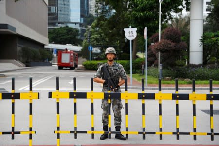 A Chinese PLA soldier guards the entrance to the PLA Hong Kong Garrison headquarters in the Central Business District in Hong Kong
