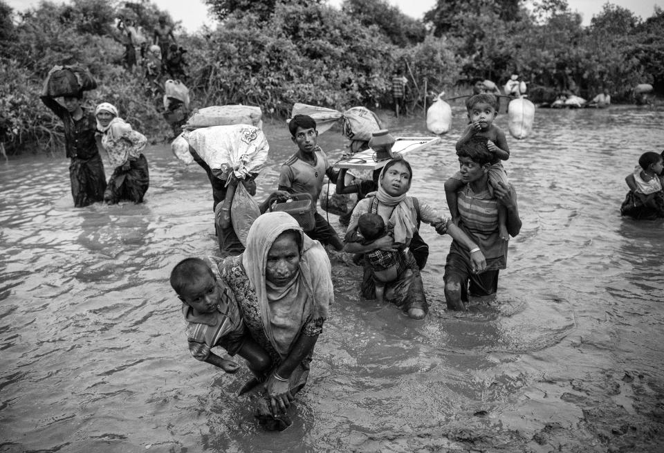 Rohingya Muslim refugees cross a canal as they flee over the border from Myanmar into Bangladesh at the Naf River on Nov. 1, 2017 near Anjuman Para in Cox's Bazar, Bangladesh. | Kevin Frayer—Getty Images