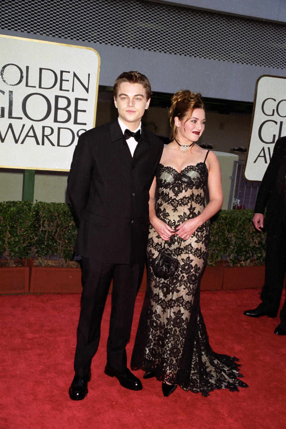 Leonardo DiCaprio and Kate Winslet wearing a black and nude lace stretch Pamela Dennis dress attends the Golden Globe awards on January 18, 1998 in Los Angeles, California. Article title: "Eye: Spanning the Globes" (Photo by Donato Sardella/WWD/Penske Media via Getty Images)