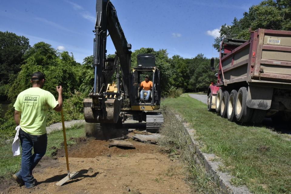 A crew from Hunter-Prell Co. removes pavement from a portion of Linear Park Path on the banks of the Kalamazoo River on Friday, Aug. 12, 2022 in Battle Creek.