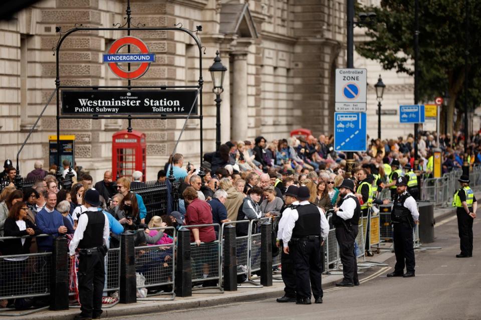 Members of the public wait on Whitehall road ahead of the ceremonial procession of the coffin of Britain's Queen Elizabeth II (POOL/AFP via Getty Images)