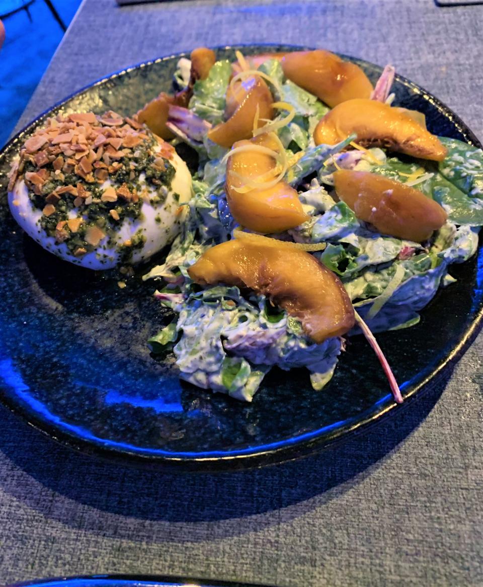 Kyle G's Oyster & Wine Bar serves a roasted and chilled peach and burrata salad of beautiful crisp fresh greens dotted with grilled peaches, a large portion of soft, rich burrata topped with chopped almonds