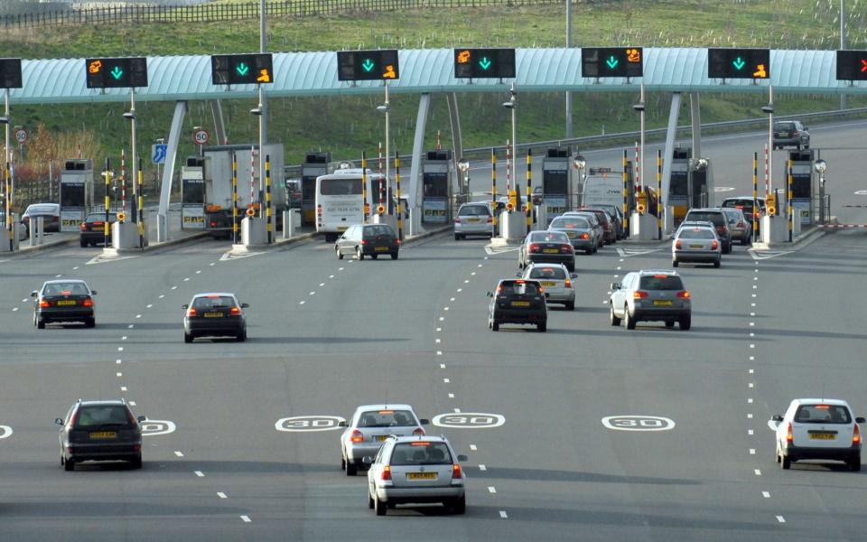 TRAFFIC APPROACHING TOLL PAYMENT BOOTHS ON THE M6 TOLL ROAD - Rosemary Roberts / Alamy Stock Photo 