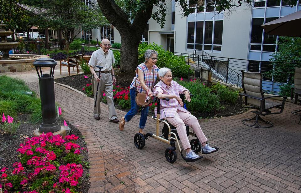 Donna Snyder helps her mother, Hermyne, back into their home June 1 after she posed for a photo with her husband of 74 years, Bernard. Hermyne died July 17.