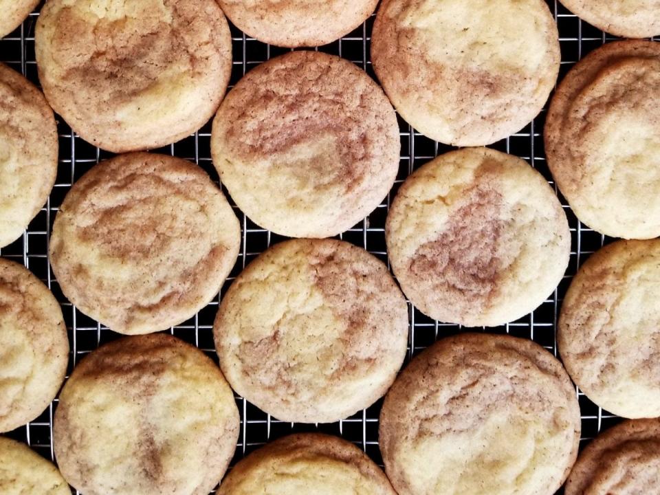 Pumpkin spice snickerdoodle cookies on a rack.