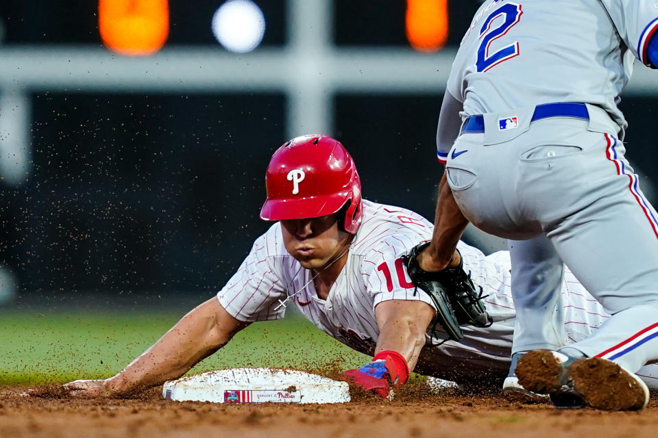 Philadelphia Phillies' J.T. Realmuto beats the throw to Texas Rangers' Marcus Semien at second after a wild pitch by Jon Gray during during the third inning of a baseball game Tuesday, May 3, 2022, in Philadelphia. (AP Photo/Matt Rourke)