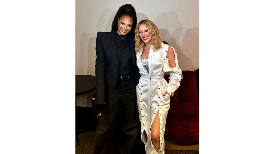 Janet Jackson in a black outfit and Kylie Minogue in a silver outfit