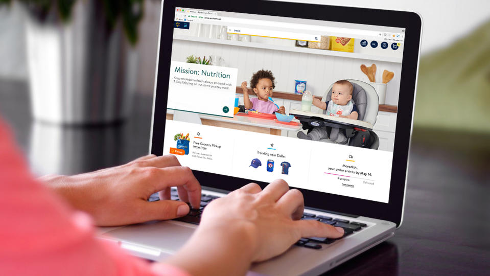 A person's hands on the keyboard of a laptop displaying Walmart.com