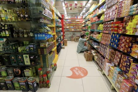FILE PHOTO: A shopkeeper arranges grocery items at a store in Peshawar