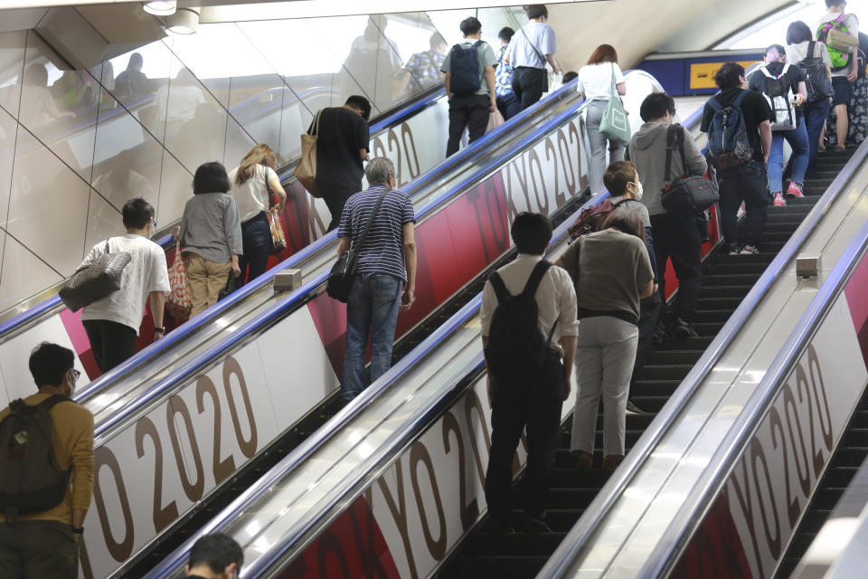 People ride escalators with banners to promote the Tokyo Olympics scheduled to open on July 23, in Tokyo, Tuesday, July 6, 2021. (AP Photo/Koji Sasahara)