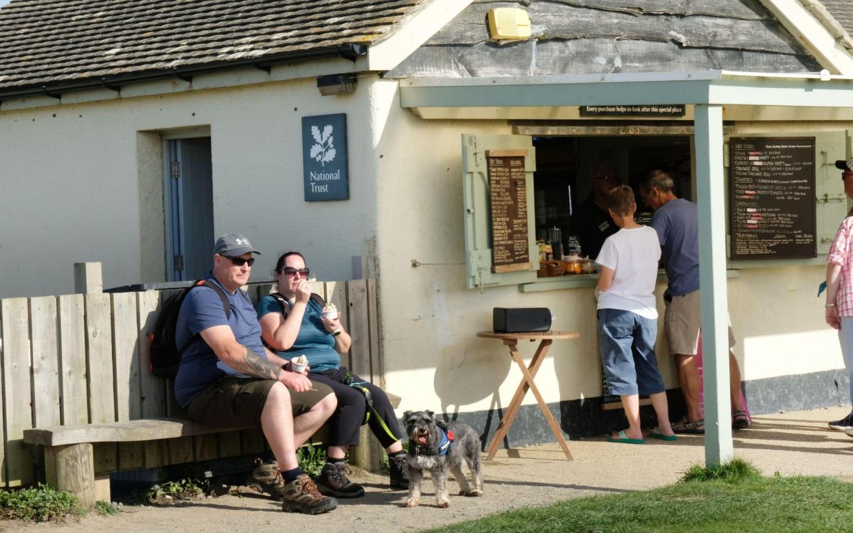 Holidaymakers enjoy a snack at the cafe in Gunwalloe, Cornwall