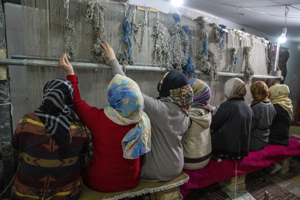 Afghan girls weave a carpet at a traditional carpet factory in Kabul, Afghanistan, Monday, March 6, 2023. After the Taliban came to power in Afghanistan, women have been deprived of many of their basic rights. (AP Photo/Ebrahim Noroozi)