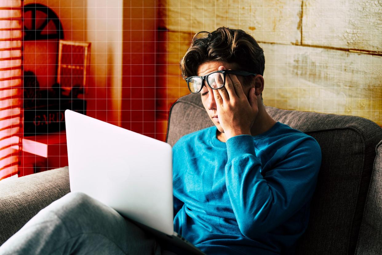 Stressed student at home studying with personal laptop computer