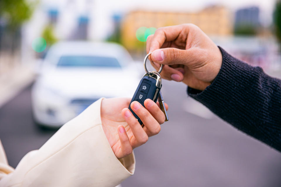 person handing someone else car keys